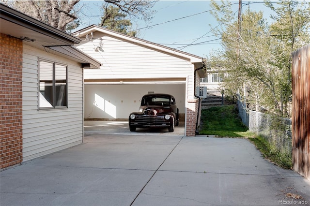 garage featuring fence and driveway
