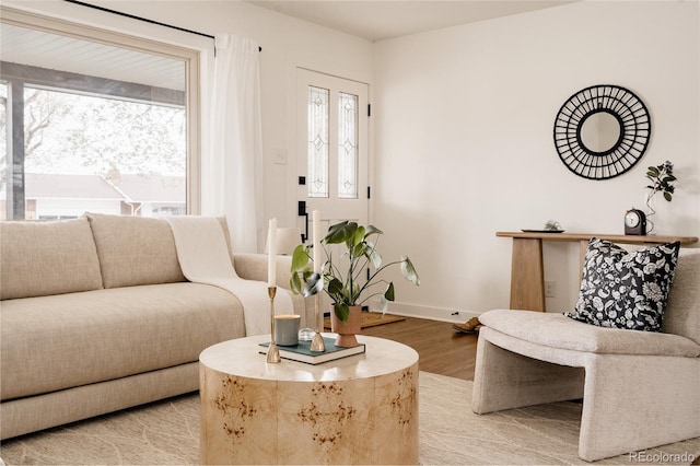 living area featuring baseboards and light wood-type flooring