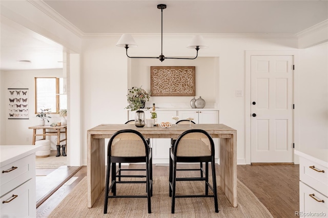 dining room featuring light wood-type flooring and ornamental molding