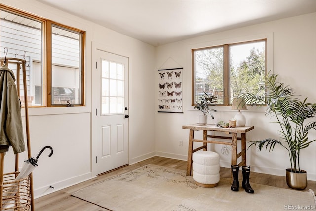 doorway featuring baseboards and light wood-style flooring