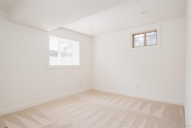 unfurnished room with carpet floors, baseboards, and a wealth of natural light