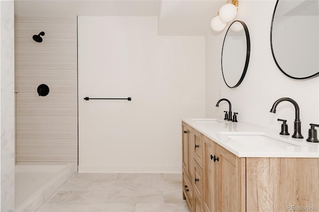 bathroom featuring double vanity, a sink, and a shower