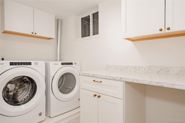 clothes washing area featuring separate washer and dryer and cabinet space