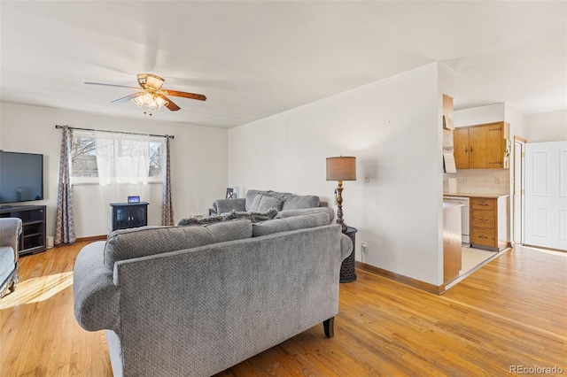 living room featuring light hardwood / wood-style floors and ceiling fan