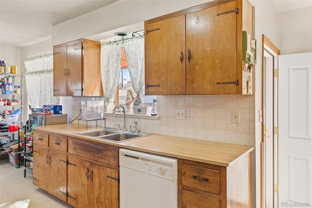 kitchen featuring pendant lighting, sink, light tile patterned floors, white dishwasher, and tasteful backsplash