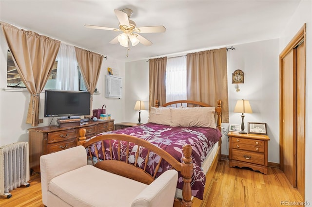 bedroom with radiator heating unit, a closet, ceiling fan, and light wood-type flooring