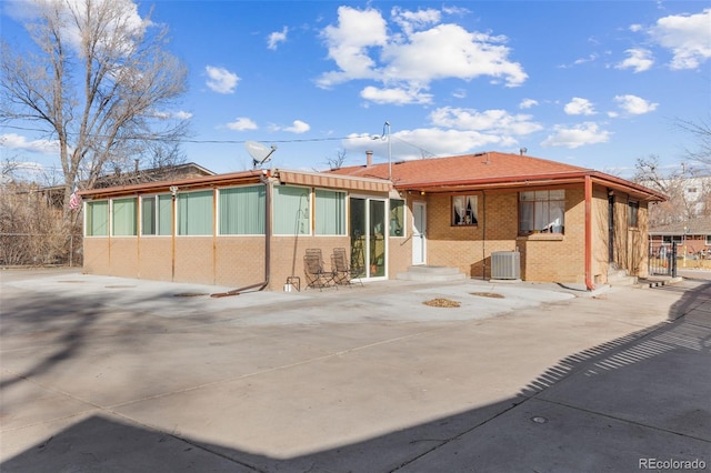 rear view of property with central AC unit and a patio area