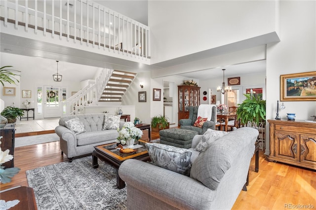 7330 Routt St, Arvada, CO 80005 - living room with a towering ceiling, a chandelier, stairs, and light wood-style floors