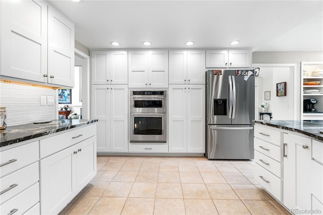 7330 Routt St, Arvada, CO 80005 - kitchen featuring appliances with stainless steel finishes, light tile patterned flooring, recessed lighting, decorative backsplash, and dark stone counters