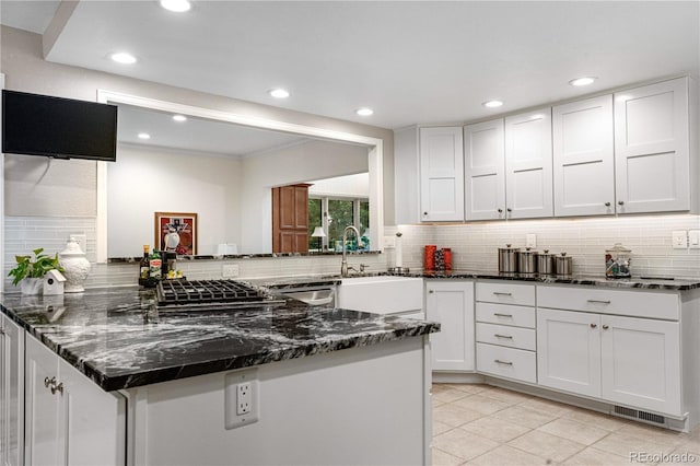 7330 Routt St, Arvada, CO 80005 - kitchen featuring backsplash, white cabinets, light tile patterned floors, dark stone counters, and recessed lighting