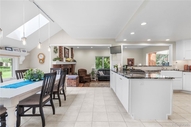 7330 Routt St, Arvada, CO 80005 - kitchen with dark stone counters, light tile patterned floors, recessed lighting, plenty of natural light, and white cabinetry
