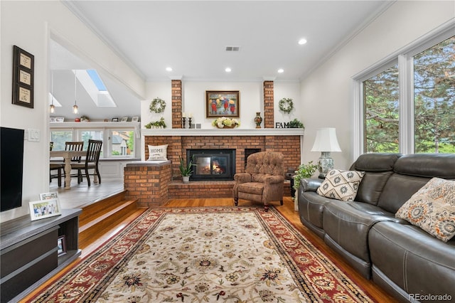 7330 Routt St, Arvada, CO 80005 - living room featuring a skylight, wood finished floors, a brick fireplace, crown molding, and recessed lighting