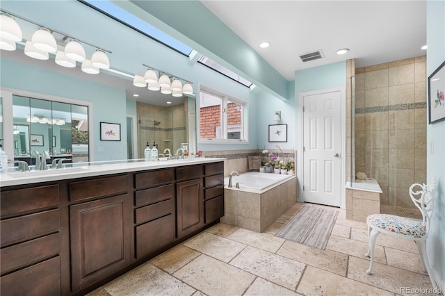 7330 Routt St, Arvada, CO 80005 - full bath with a stall shower, a bath, double vanity, stone tile flooring, and recessed lighting