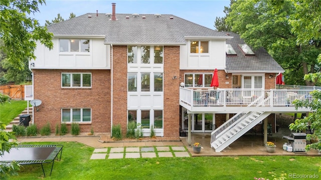 7330 Routt St, Arvada, CO 80005 - back of property featuring a wooden deck, brick siding, a lawn, stairway, and a patio