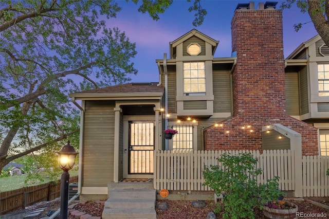 view of front of home featuring fence and a chimney