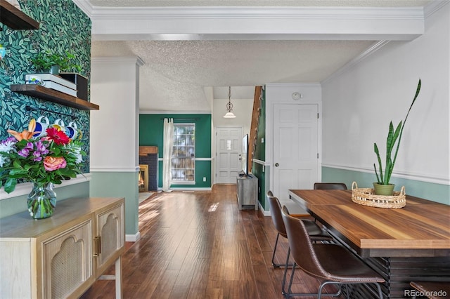 dining area featuring dark wood-type flooring, baseboards, a brick fireplace, and crown molding