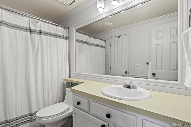 bathroom with crown molding, vanity, and toilet