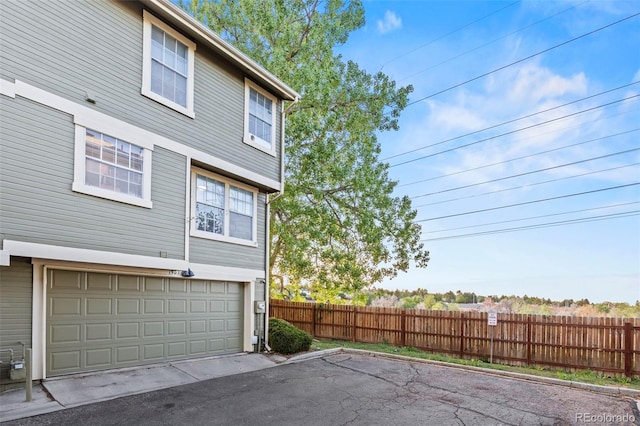 view of home's exterior with fence and an attached garage
