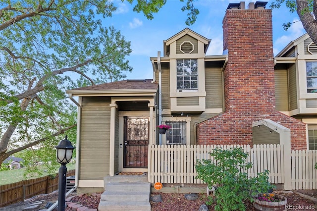 view of front of house with fence and a chimney