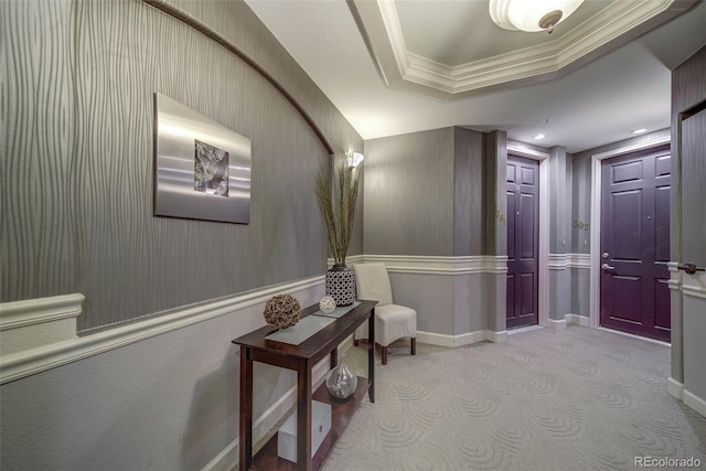 corridor featuring a raised ceiling, light carpet, and ornamental molding