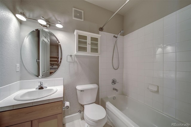 full bathroom featuring tiled shower / bath, vanity, and toilet