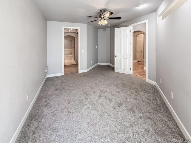 unfurnished bedroom with carpet flooring, ceiling fan, and a spacious closet