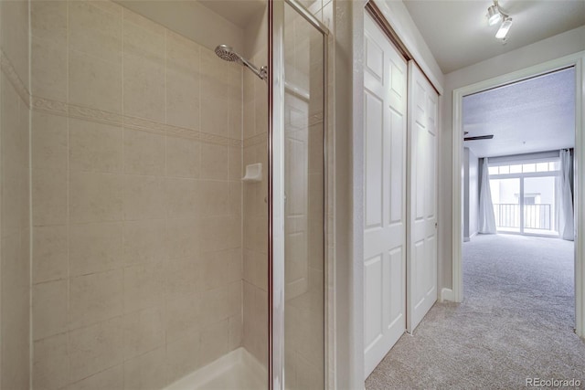 bathroom featuring a shower with door and a textured ceiling