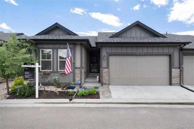 11823 Barrentine Loop, Parker, CO 80138 - view of front of home with stone siding, an attached garage, board and batten siding, driveway, and roof with shingles