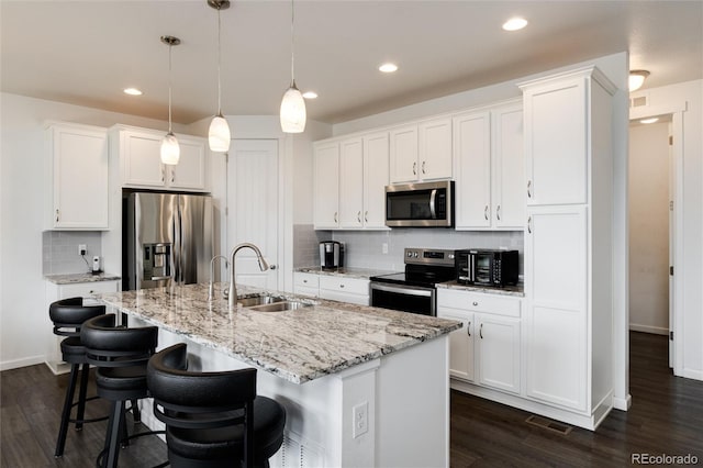 11823 Barrentine Loop, Parker, CO 80138 - kitchen featuring appliances with stainless steel finishes, dark wood-style floors, white cabinets, and recessed lighting