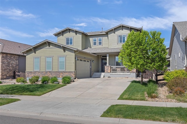 525 Grenville Cir, Erie, CO 80516 - craftsman house with a porch, driveway, a front yard, and stone siding