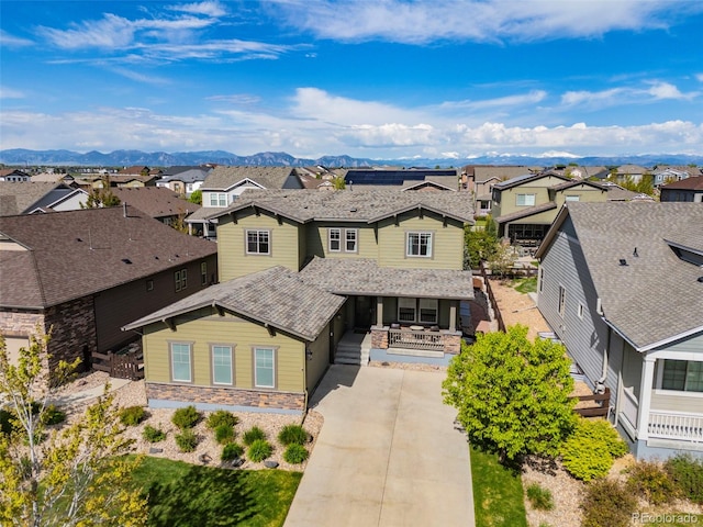 525 Grenville Cir, Erie, CO 80516 - traditional-style home with a residential view, a porch, concrete driveway, a mountain view, and stone siding