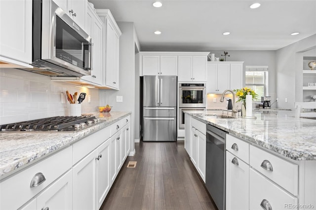 525 Grenville Cir, Erie, CO 80516 - kitchen featuring appliances with stainless steel finishes, a sink, white cabinetry, recessed lighting, and light stone counters