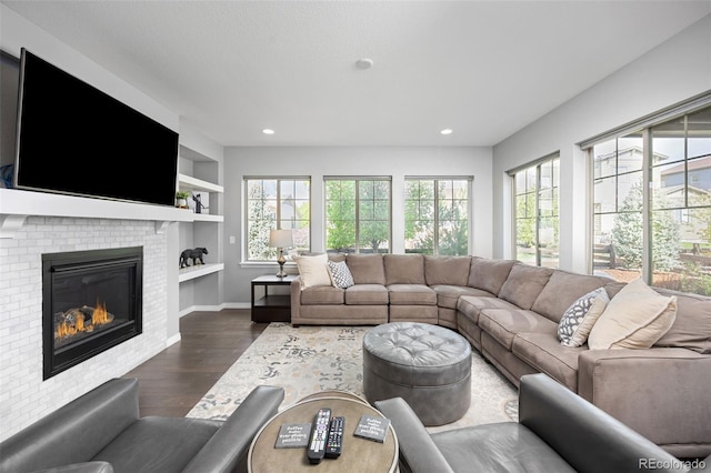 525 Grenville Cir, Erie, CO 80516 - living area featuring plenty of natural light, dark wood-style floors, built in shelves, baseboards, and recessed lighting