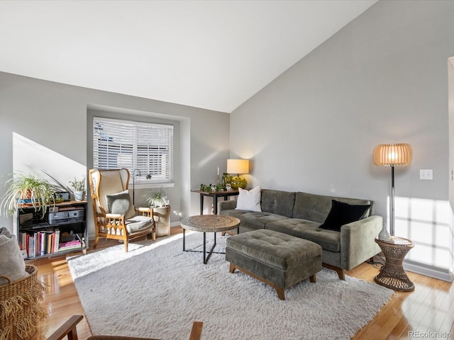 living room featuring high vaulted ceiling and light wood-type flooring