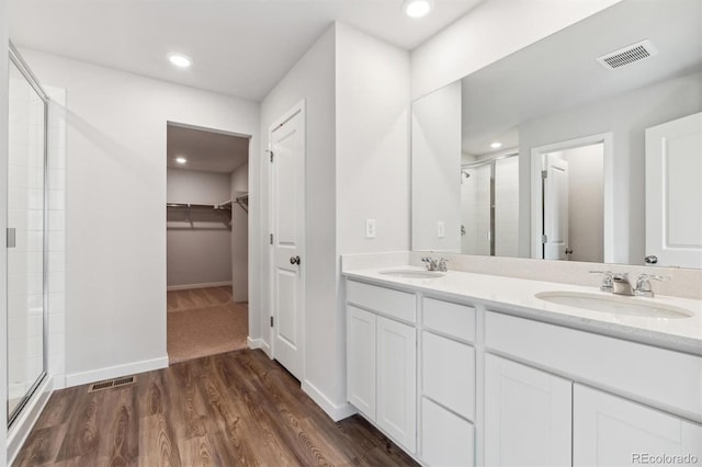 bathroom with an enclosed shower, hardwood / wood-style floors, and vanity