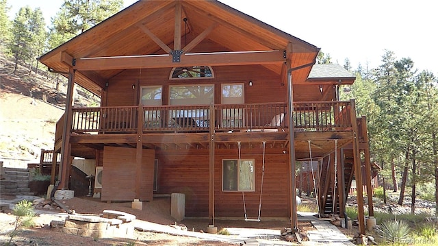 back of house featuring a shingled roof, stairway, and a wooden deck