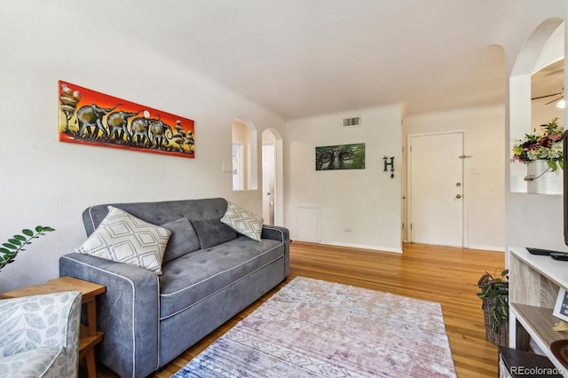 85 N Grant St Unit 28, Denver, CO 80203 - living room with arched walkways, wood finished floors, and baseboards