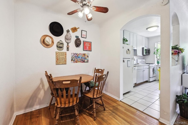 85 N Grant St Unit 28, Denver, CO 80203 - dining room with arched walkways, baseboards, ceiling fan, and light wood-style flooring