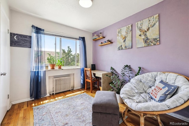 85 N Grant St Unit 28, Denver, CO 80203 - sitting room with radiator, wood finished floors, and baseboards