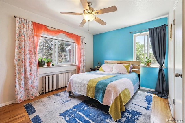 85 N Grant St Unit 28, Denver, CO 80203 - bedroom featuring radiator heating unit, wood-type flooring, baseboards, and ceiling fan