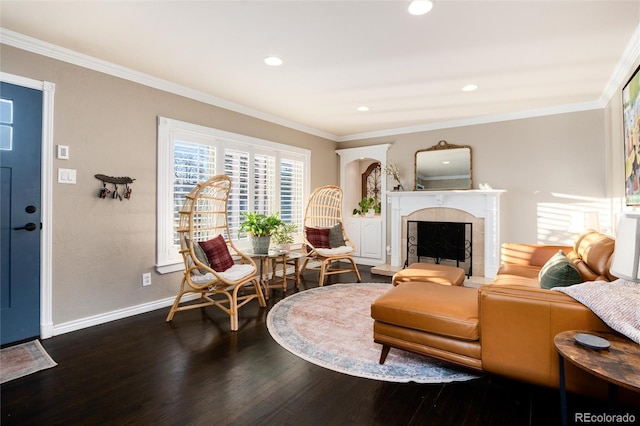 living area featuring dark wood finished floors, crown molding, recessed lighting, a fireplace with raised hearth, and baseboards