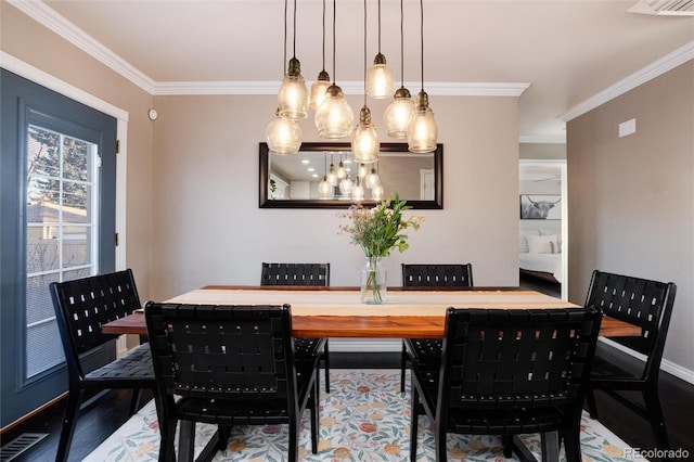 dining space featuring ornamental molding, wood finished floors, visible vents, and baseboards