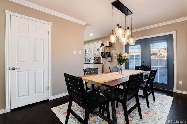 dining space featuring ornamental molding, baseboards, and wood finished floors