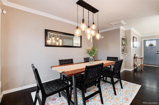 dining space with baseboards, crown molding, and wood finished floors