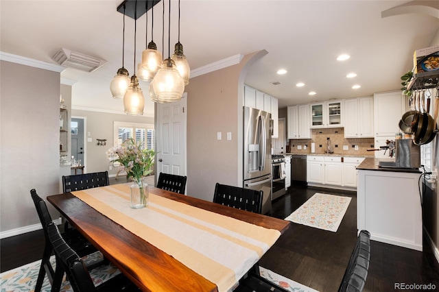 dining room with baseboards, dark wood-style flooring, recessed lighting, and crown molding