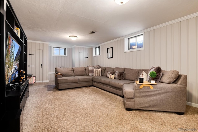 living area featuring ornamental molding, carpet, a healthy amount of sunlight, and visible vents