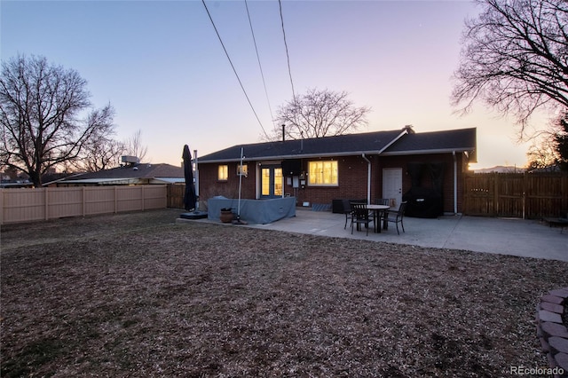 rear view of property with a patio area, a fenced backyard, and brick siding