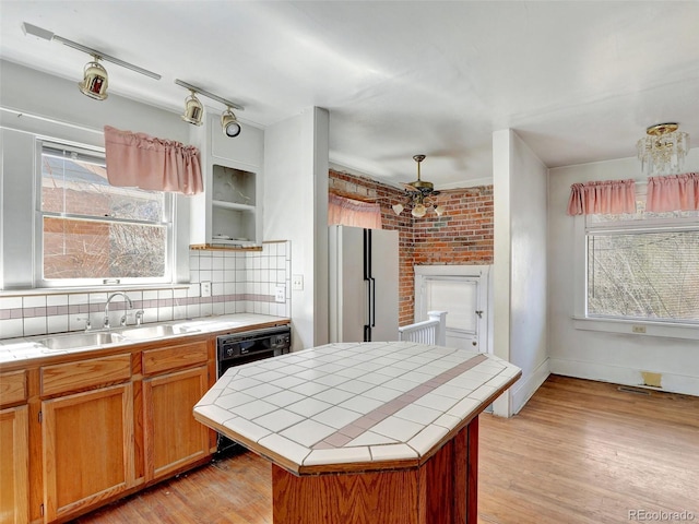 kitchen featuring tasteful backsplash, tile counters, white fridge, a kitchen island, and light hardwood / wood-style floors