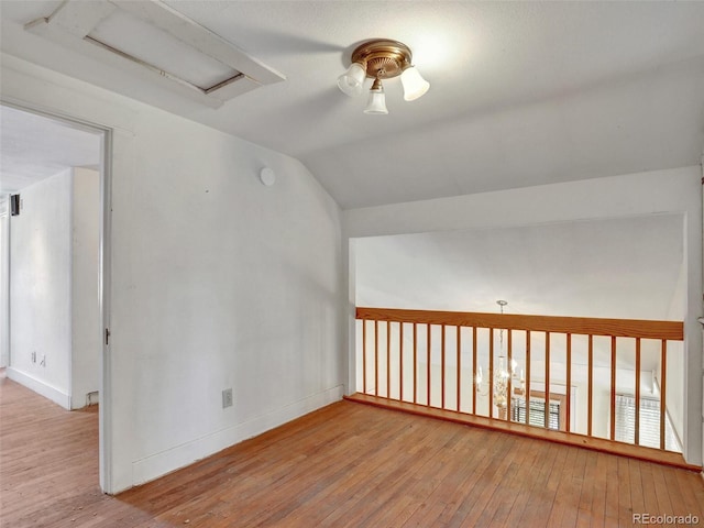 additional living space featuring vaulted ceiling and light wood-type flooring