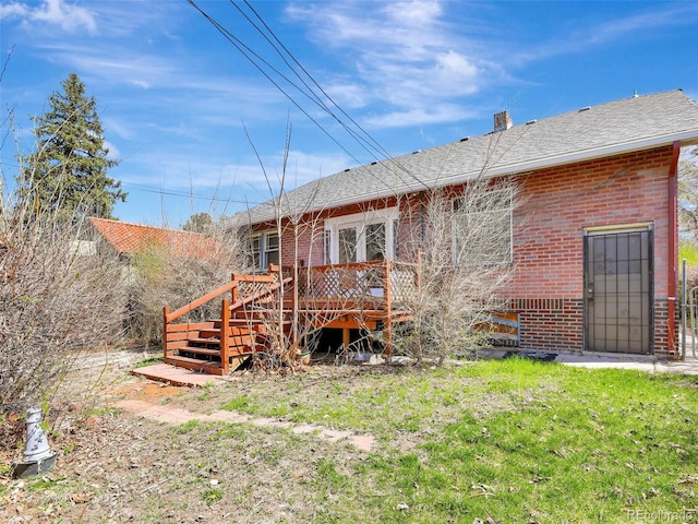 rear view of property with a deck and a lawn